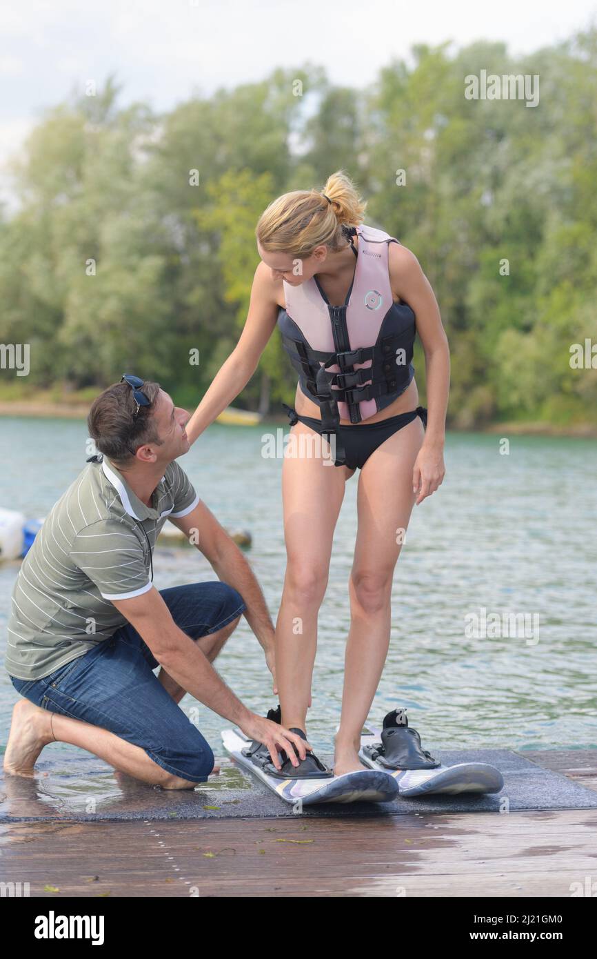 male coach helping female athlete to put water skis on Stock Photo Alamy