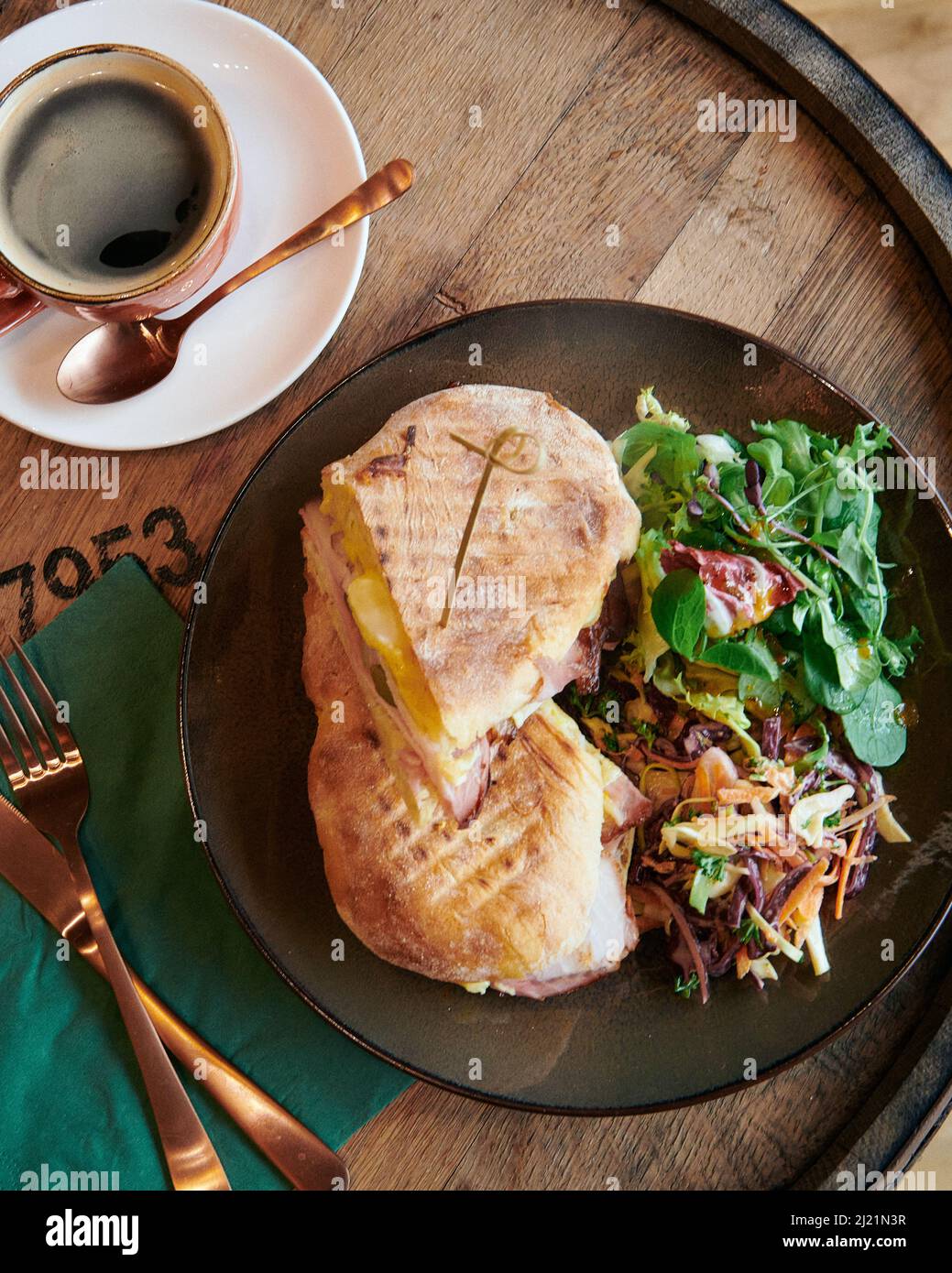 https://c8.alamy.com/comp/2J21N3R/a-deli-toasted-sandwich-with-a-fresh-black-coffee-on-a-rustic-wooden-barrel-2J21N3R.jpg