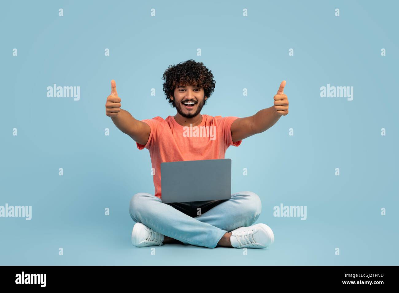 Positive hindu guy enjoying newest computer software Stock Photo