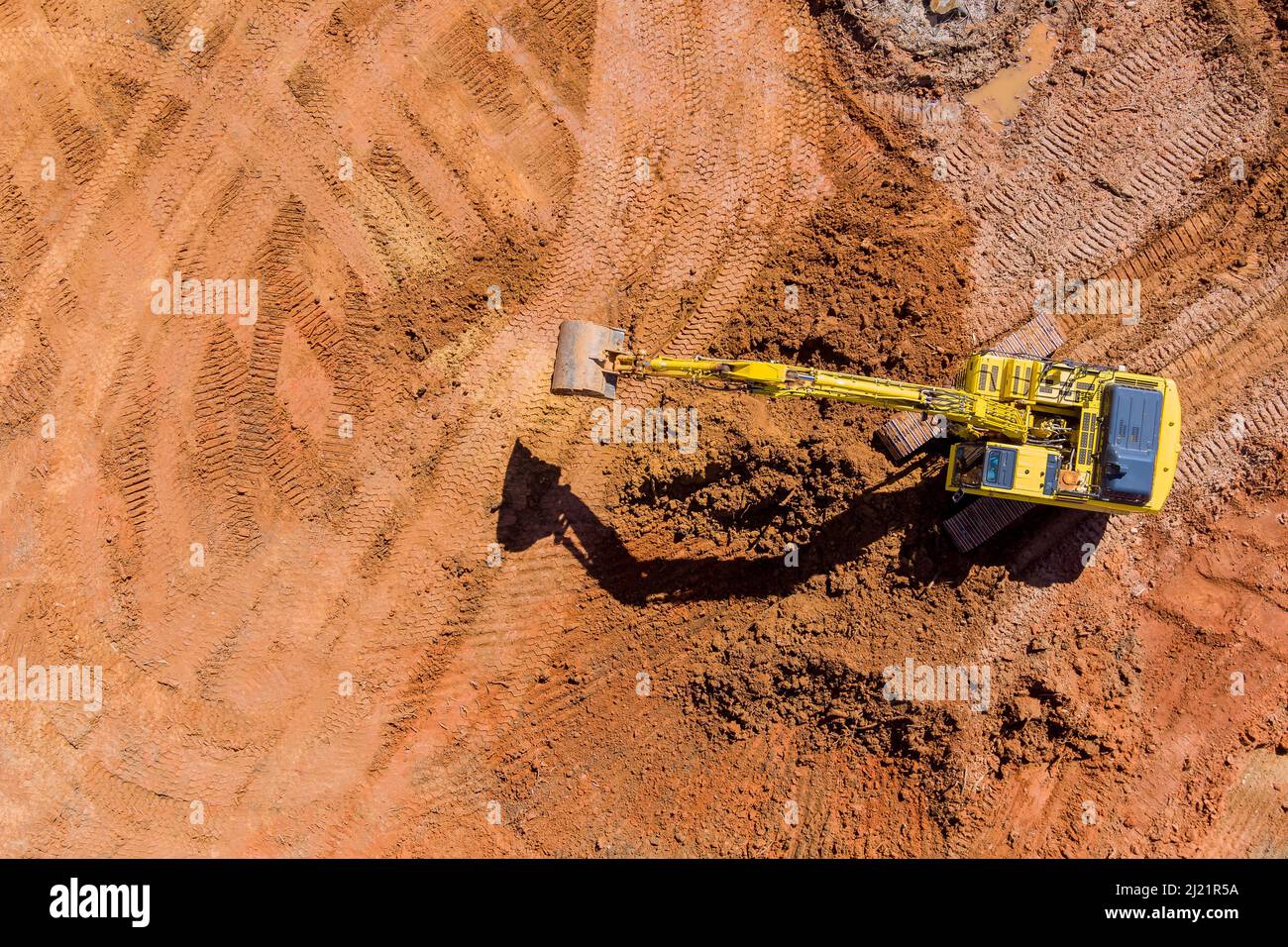 Digger on earthworks in excavator dig the trenche at construction site on arial view Stock Photo