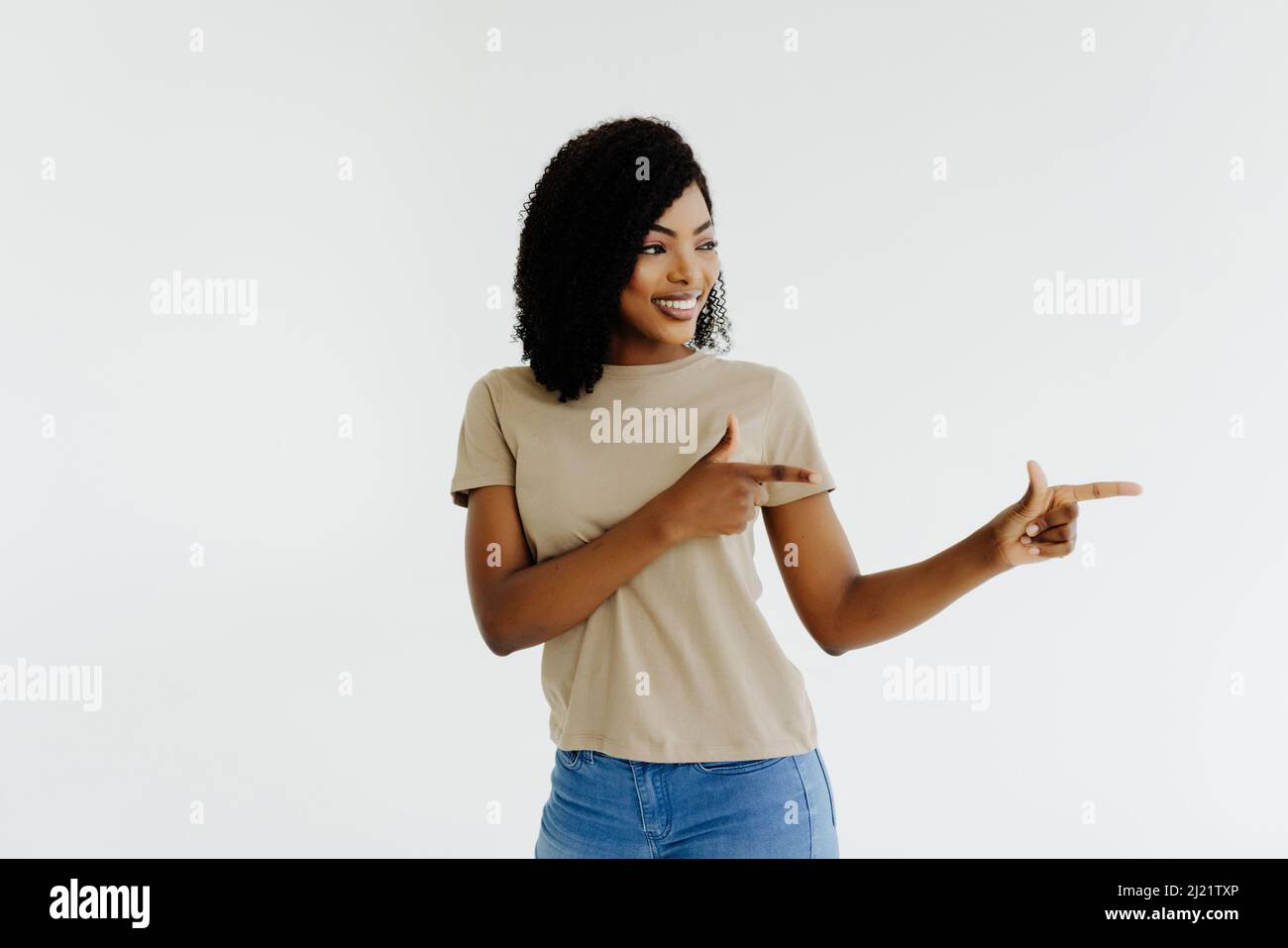 Portrait of happy young african american woman pointing at side with ...