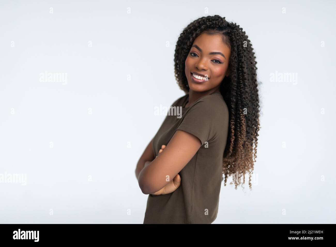 Portrait of a african woman with arms folded standing over gray ...