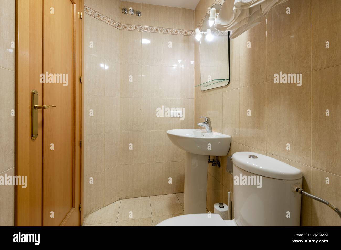 Bathroom with white porcelain fixtures and cream stoneware tiles Stock