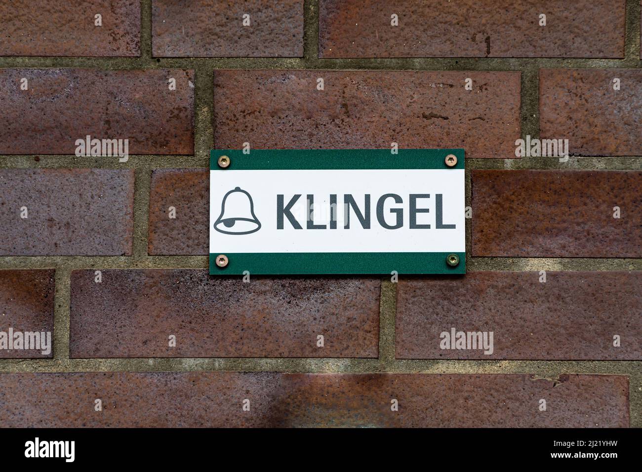 ein gruen weisses schild an der hauswand mit der info zum klingeln Stock Photo