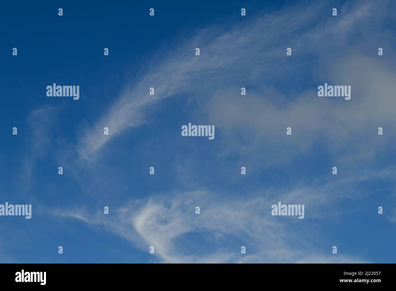 A blue sky with wispy white clouds Stock Photo - Alamy