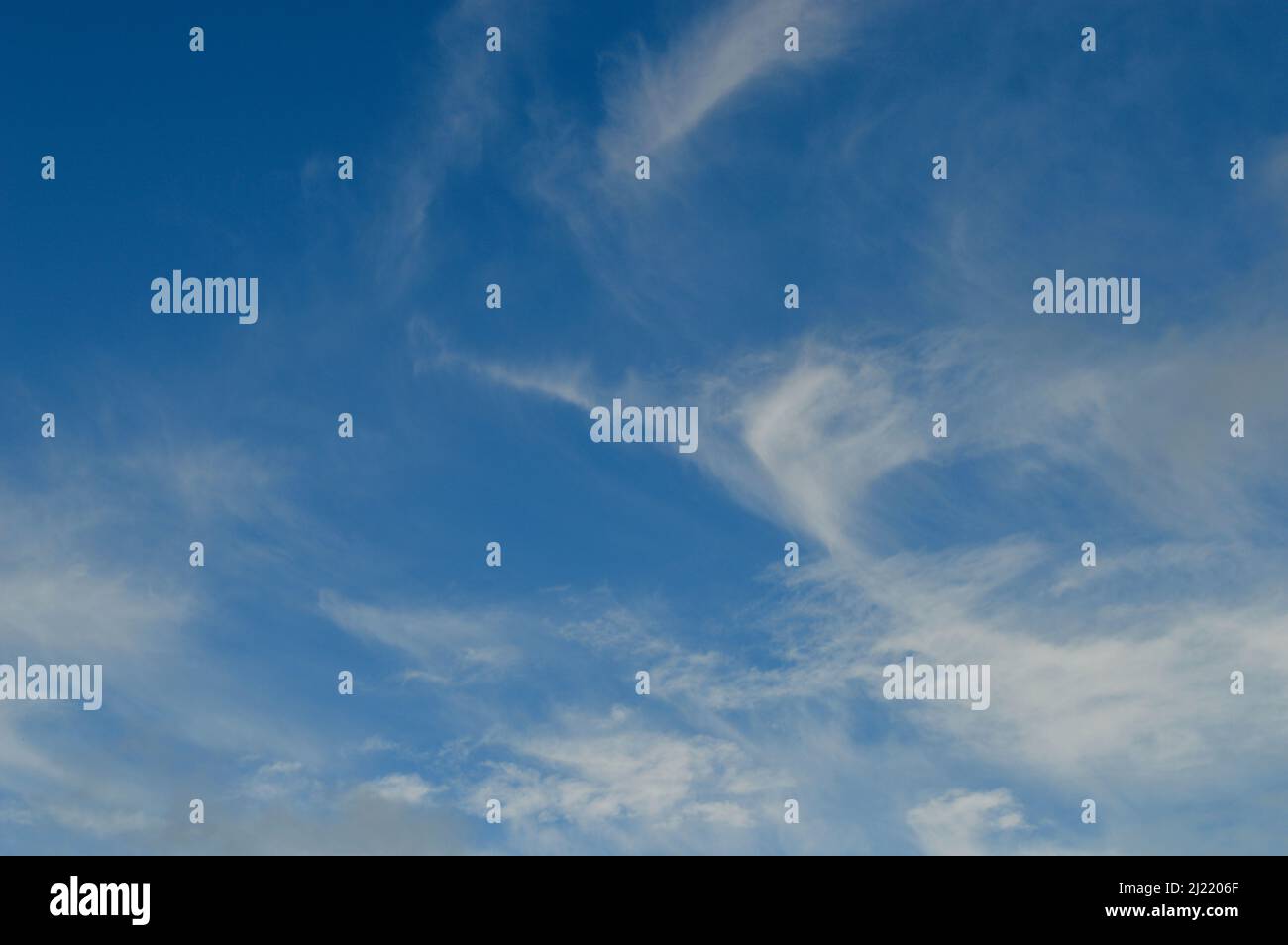 A blue sky with wispy white clouds Stock Photo - Alamy
