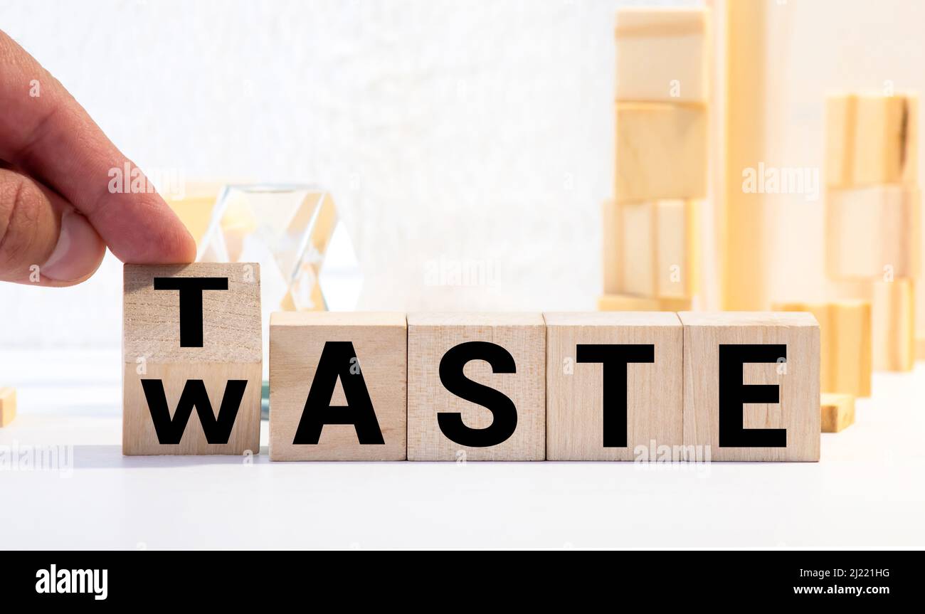 From waste to taste. Hand turns a dice and changes the word waste to taste. Stock Photo