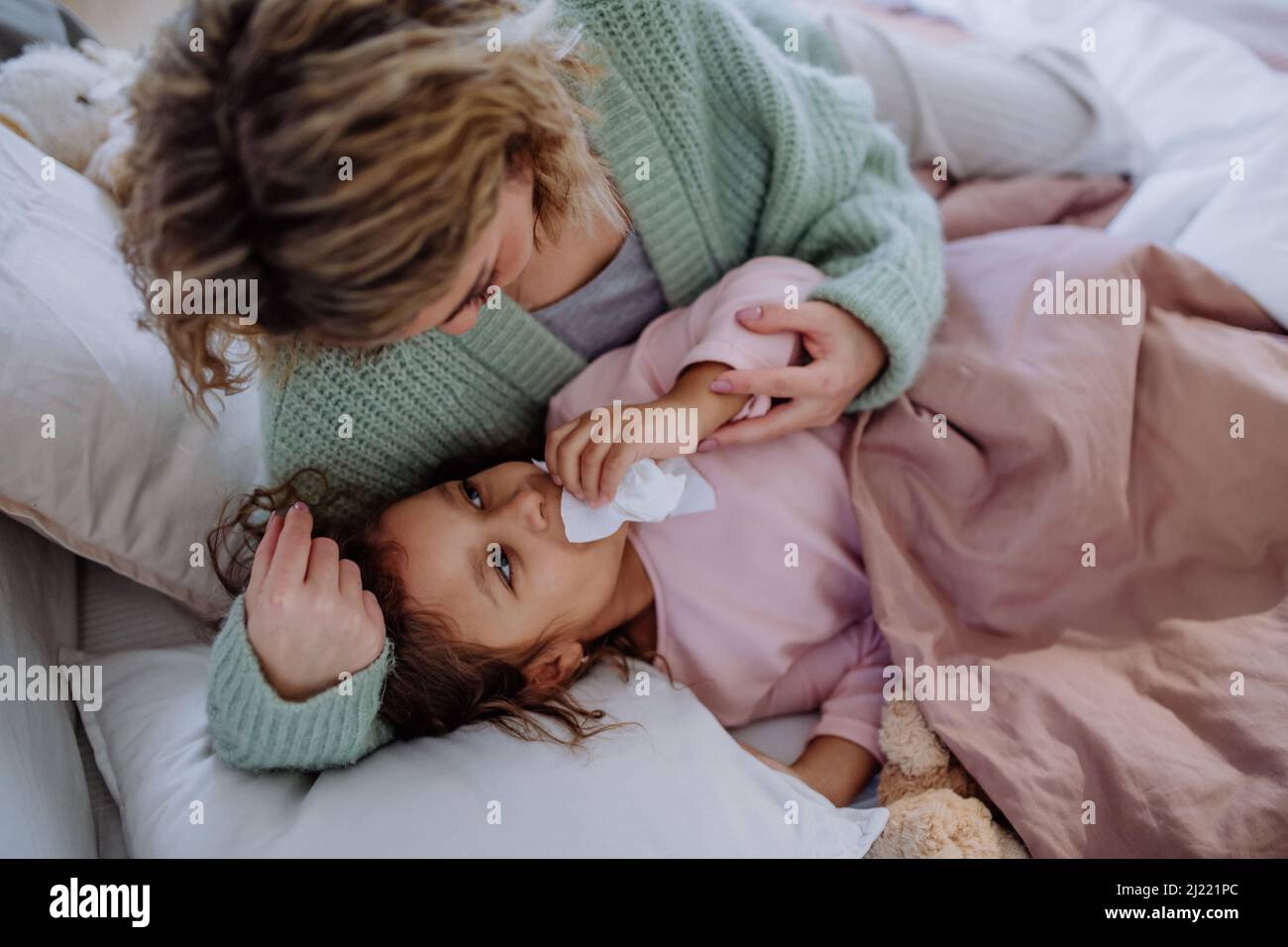 Mother taking care of her ill daughter at home. Stock Photo