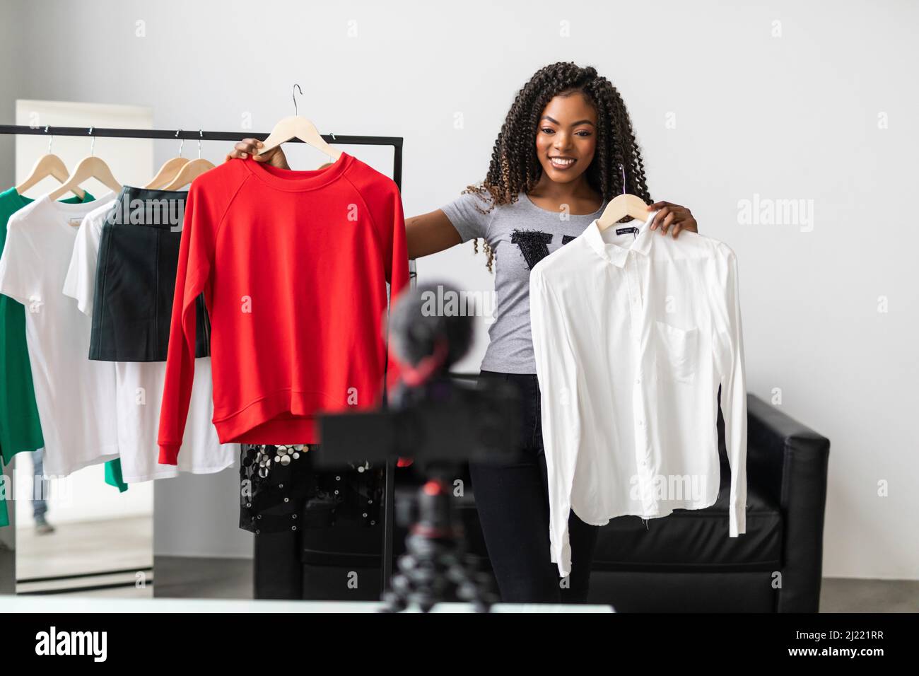 Young beautiful stylist showing her wardrobe in living room Stock Photo Alamy