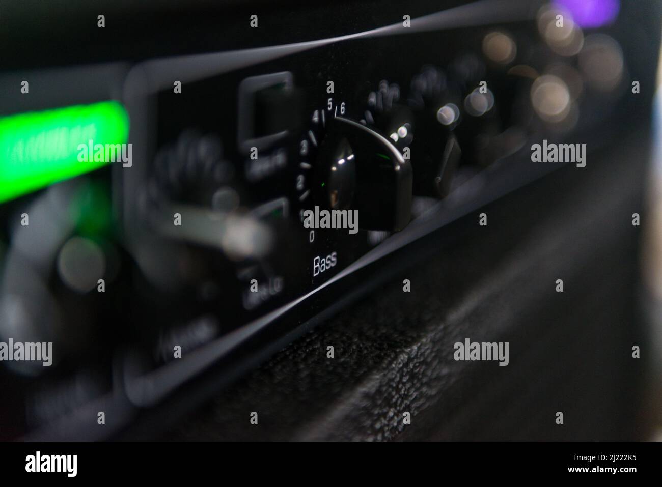 Close-up of the knob that controls the bass sound of a musical amp. Part of it appears out of focus Stock Photo