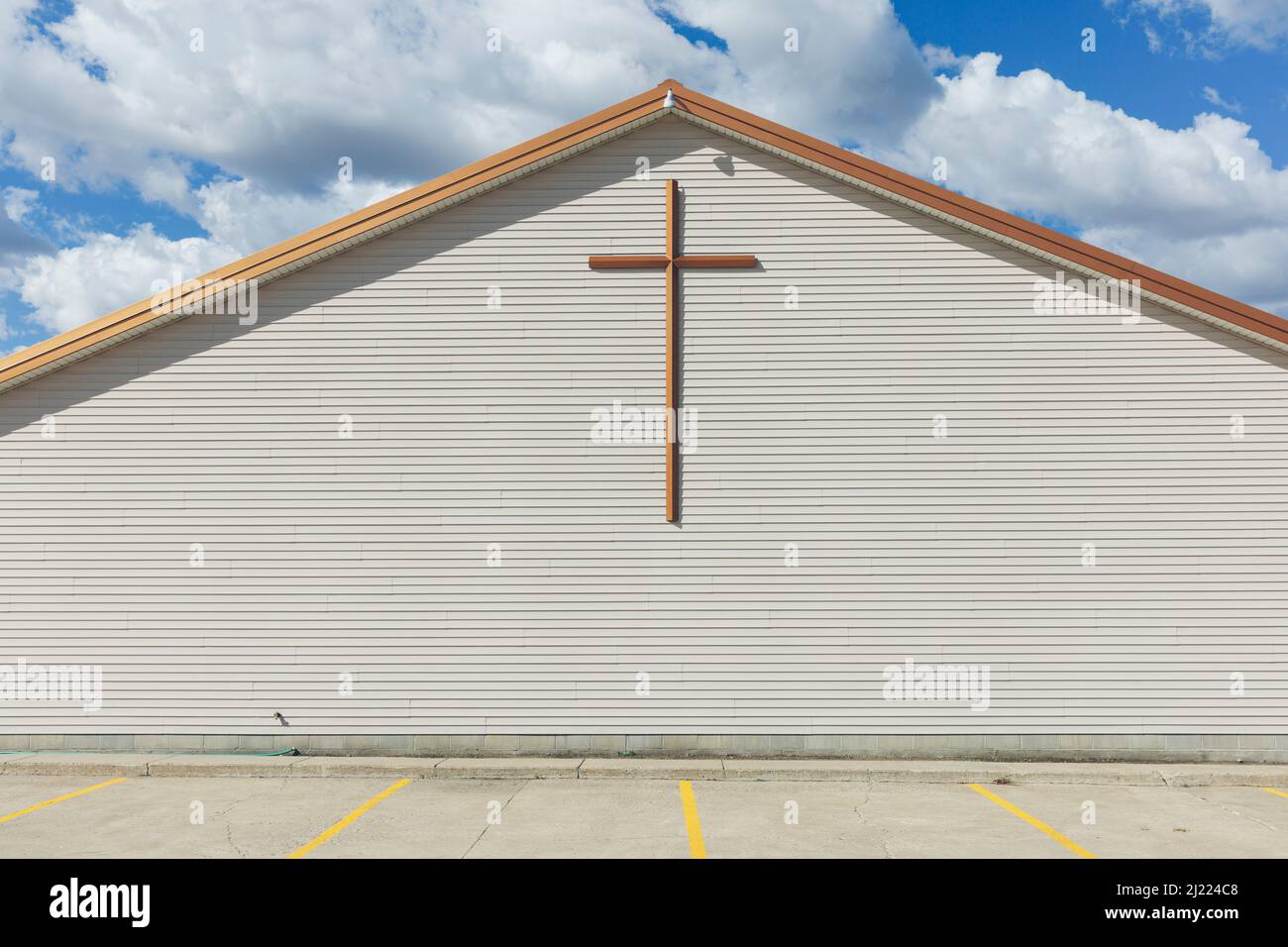 A large cross on the exterior wall of a church in a small town. Stock Photo