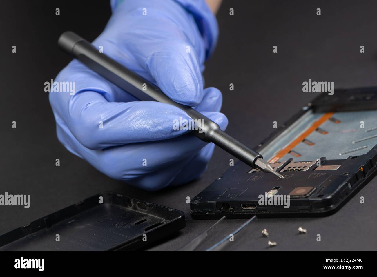 Process of mobile phone repair. Hands of a service worker repairing modern mobile phone Stock