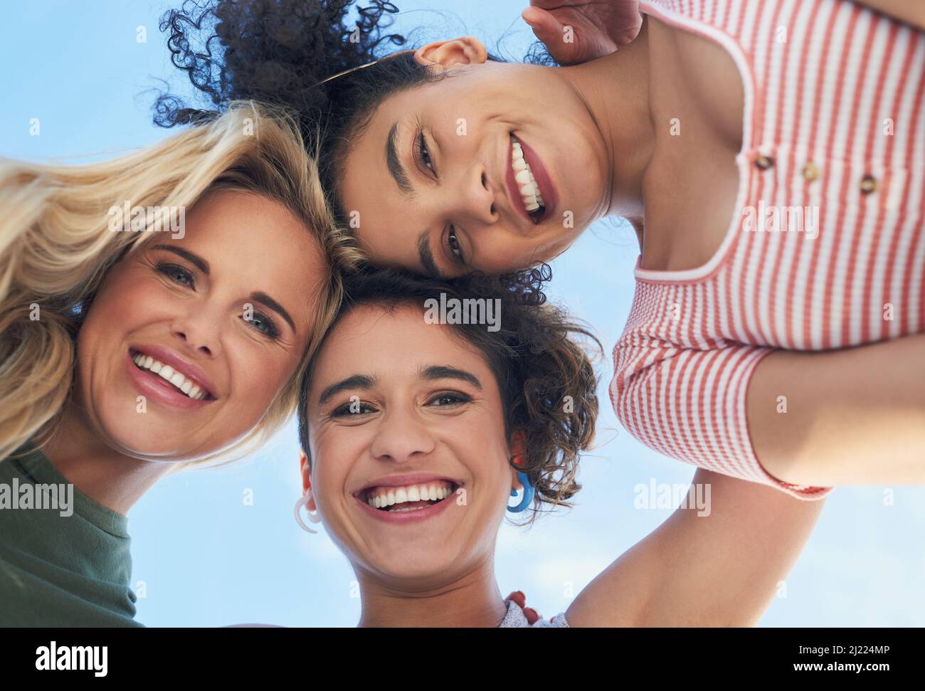 Our friendship is what matters most to us. Shot of three female friends smiling down at the camera. Stock Photo