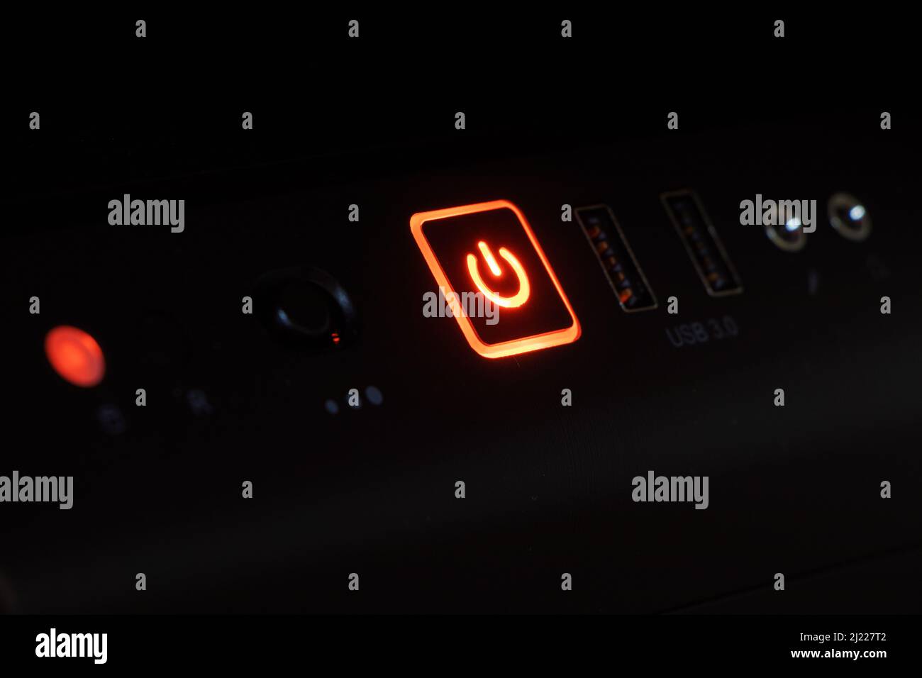 Computer power button glowing in the dark Stock Photo - Alamy