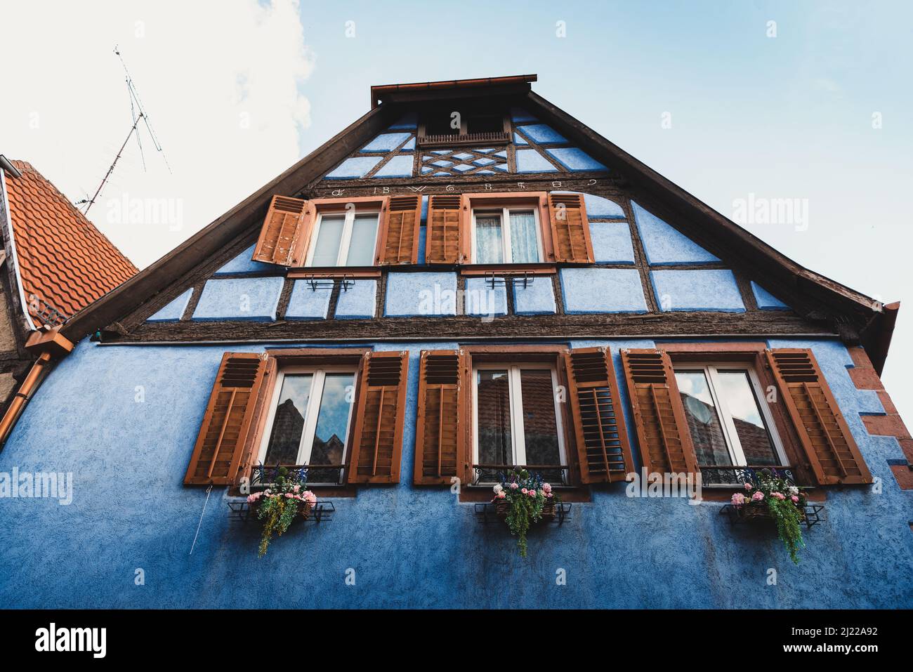 A low angle shot of a colorful traditional building with open windows in Colma, France Stock Photo