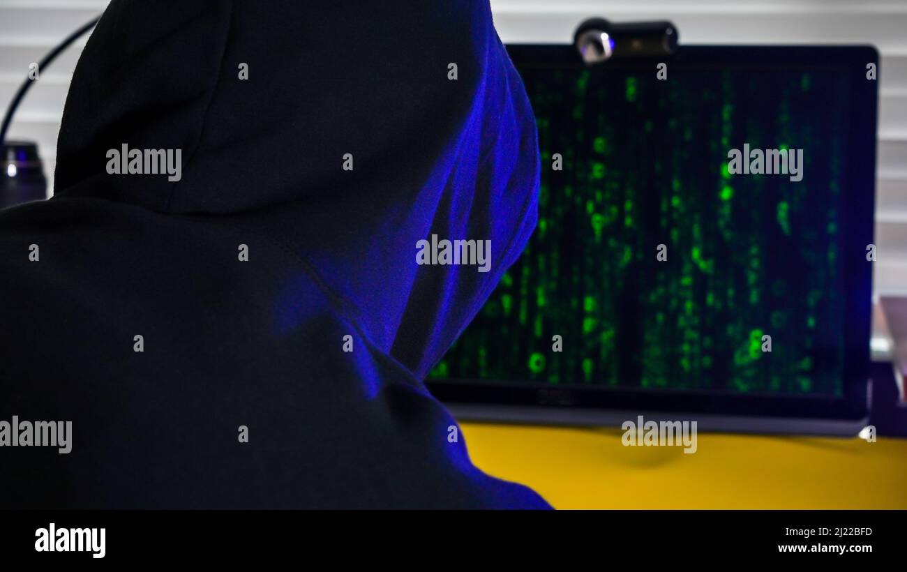 Person silhouette upfront computer screen with digital code on screen Stock Photo