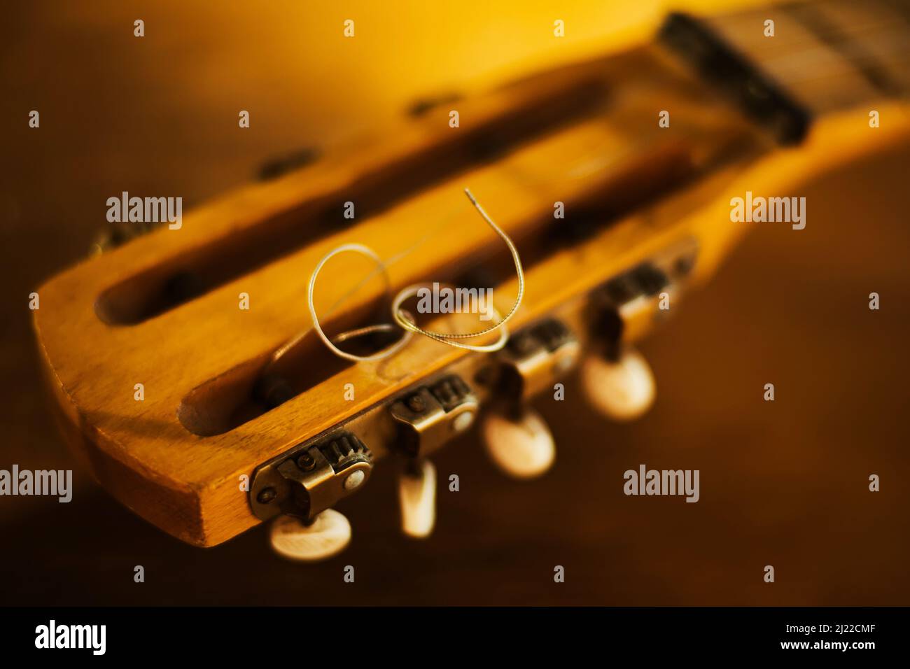 The fretboard of an old vintage guitar with metal strings on a sunny day. A musical instrument. Creation. Solfeggio. Stock Photo