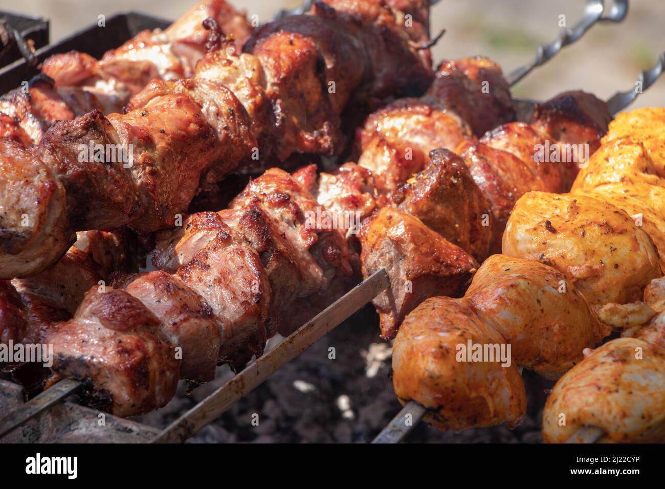 Marinated barbecue meat on skewer. Shish kebab or Shashlyk meaning skewered  meat. Beef or pork on grill on an open fire. Street food, picnic concept  Stock Photo