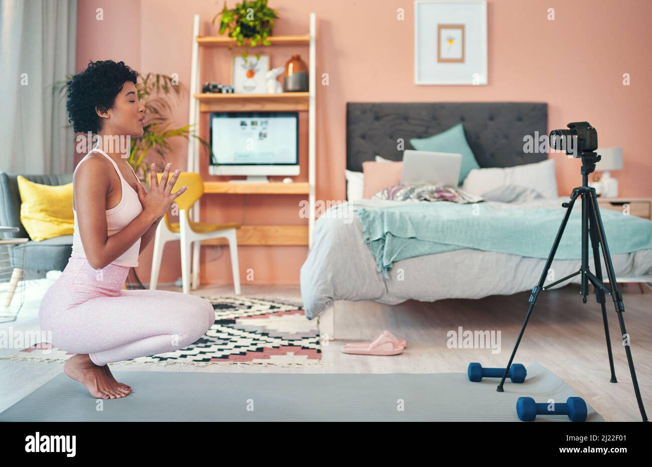 Now its time for some breathing exercises. Shot of a young woman recording herself while exercising at home. Stock Photo