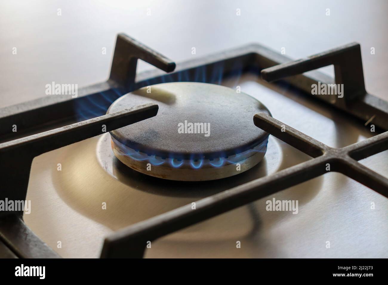 Gas hob switched on with blue flame Stock Photo