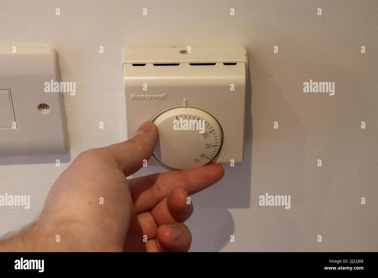 Turning down a thermostat, central heating system Stock Photo Alamy