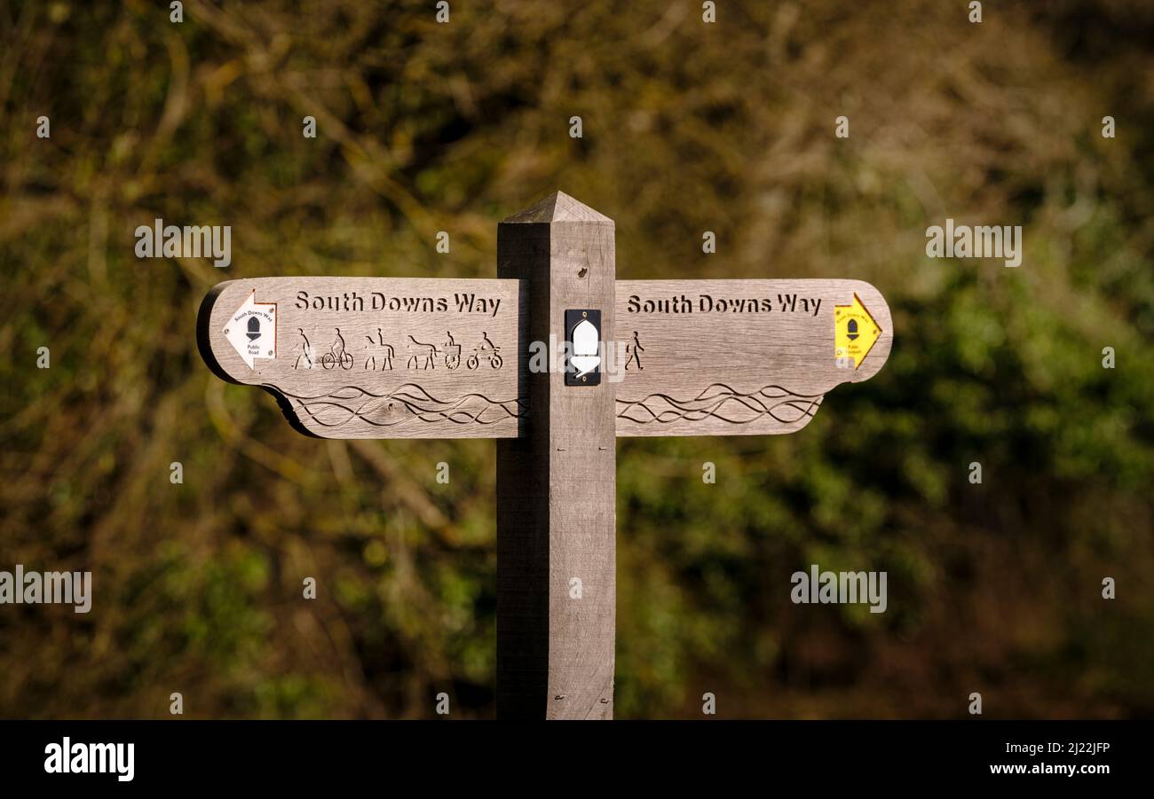 A signpost for the South Downs Way at the village of Exton. Left shows road and byway use and right shows footpath only. Stock Photo