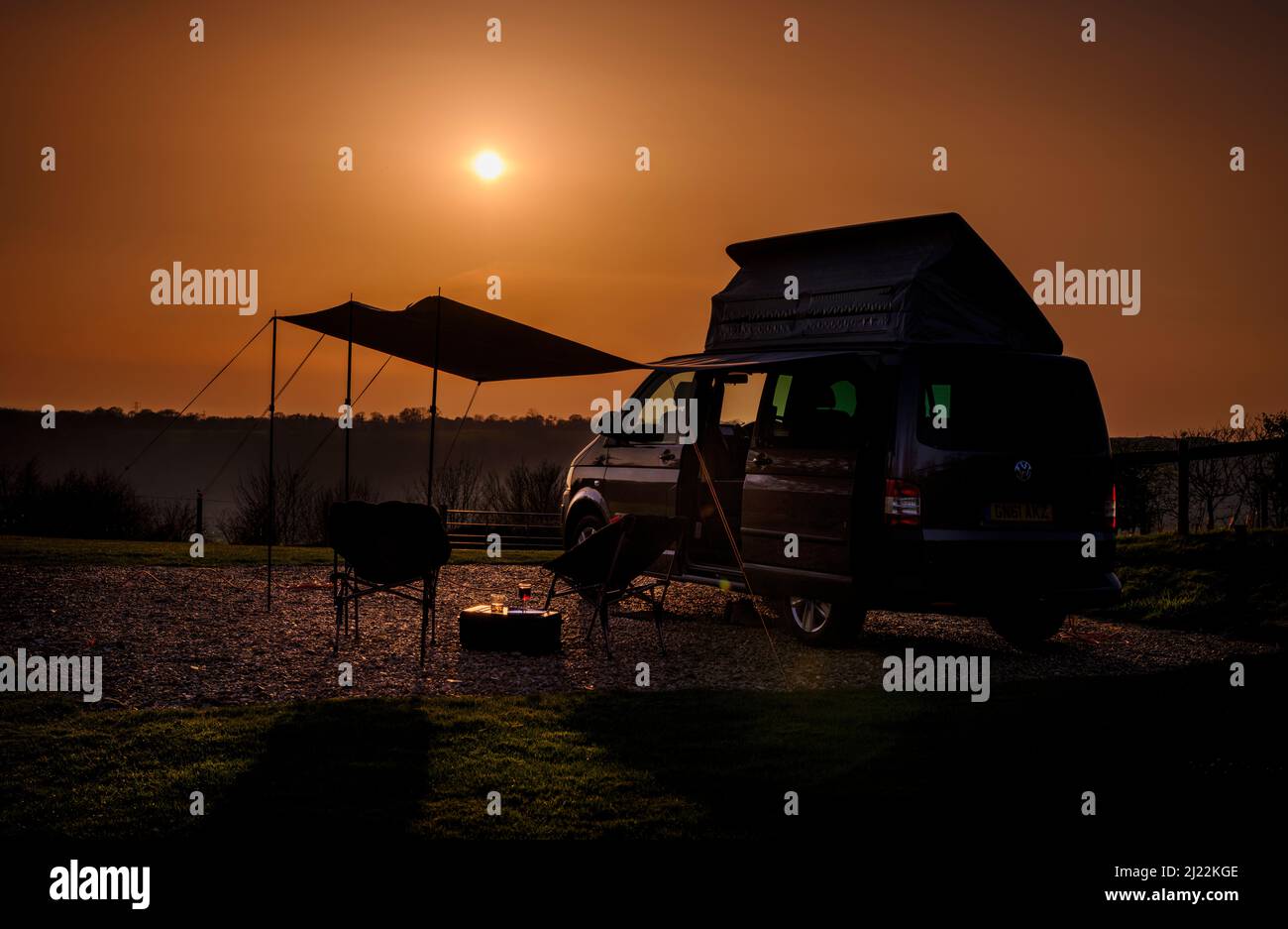 Sunset on the South Downs at Bow Hill Farm. UK camping vanlife with a VW T5 camper van and awning. Stock Photo