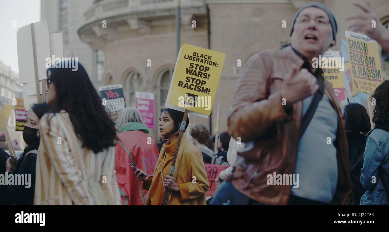 London, UK - 03 19 2022:  Protester holding sign at Portland Place, ‘Black Liberation:  Stop Wars!  Stop Racism!’, for yearly ‘March Against Racism’. Stock Photo