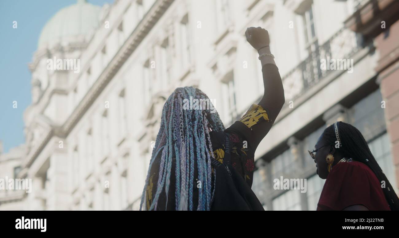 London, UK -03 19 2022: Black woman raising fist at protest on Regent Street with ‘Kill The Bill’ on arm, for the yearly ‘March Against Racism’. Stock Photo