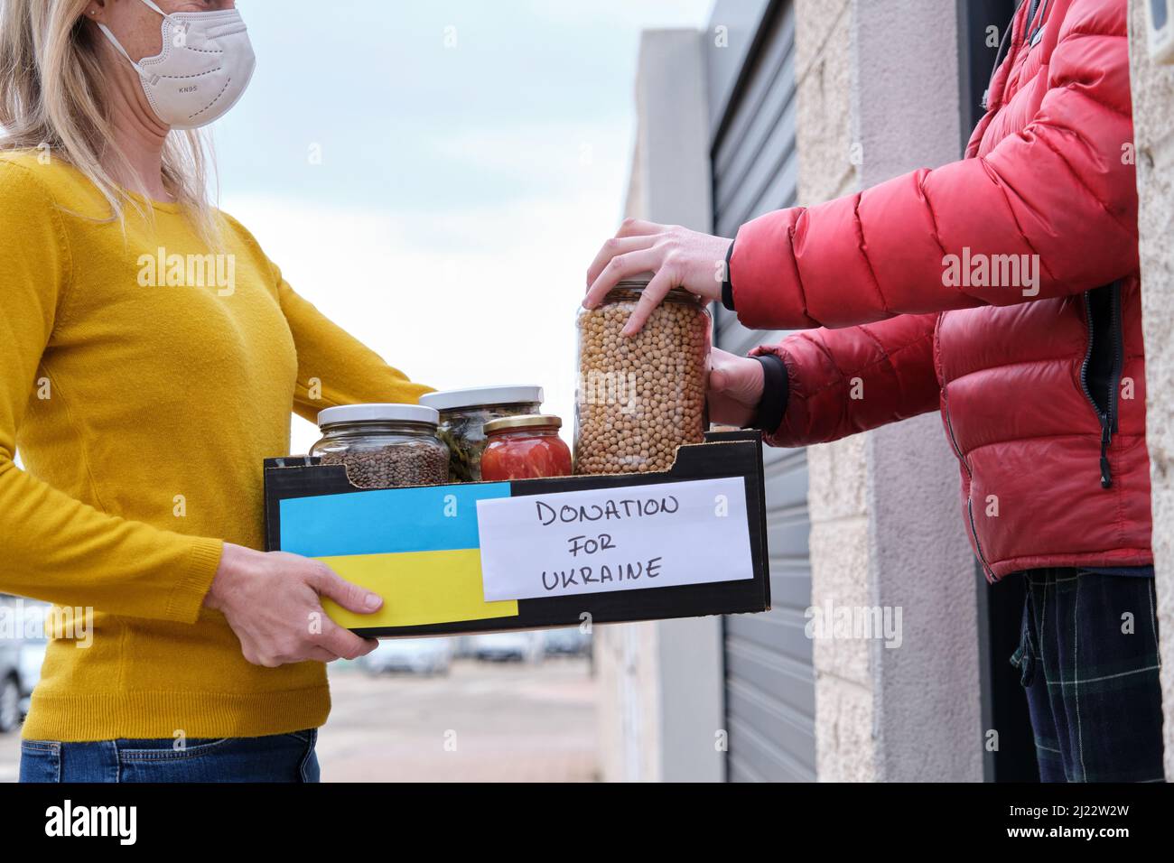 Female volunteer delivering donations to Ukrainian person Stock Photo