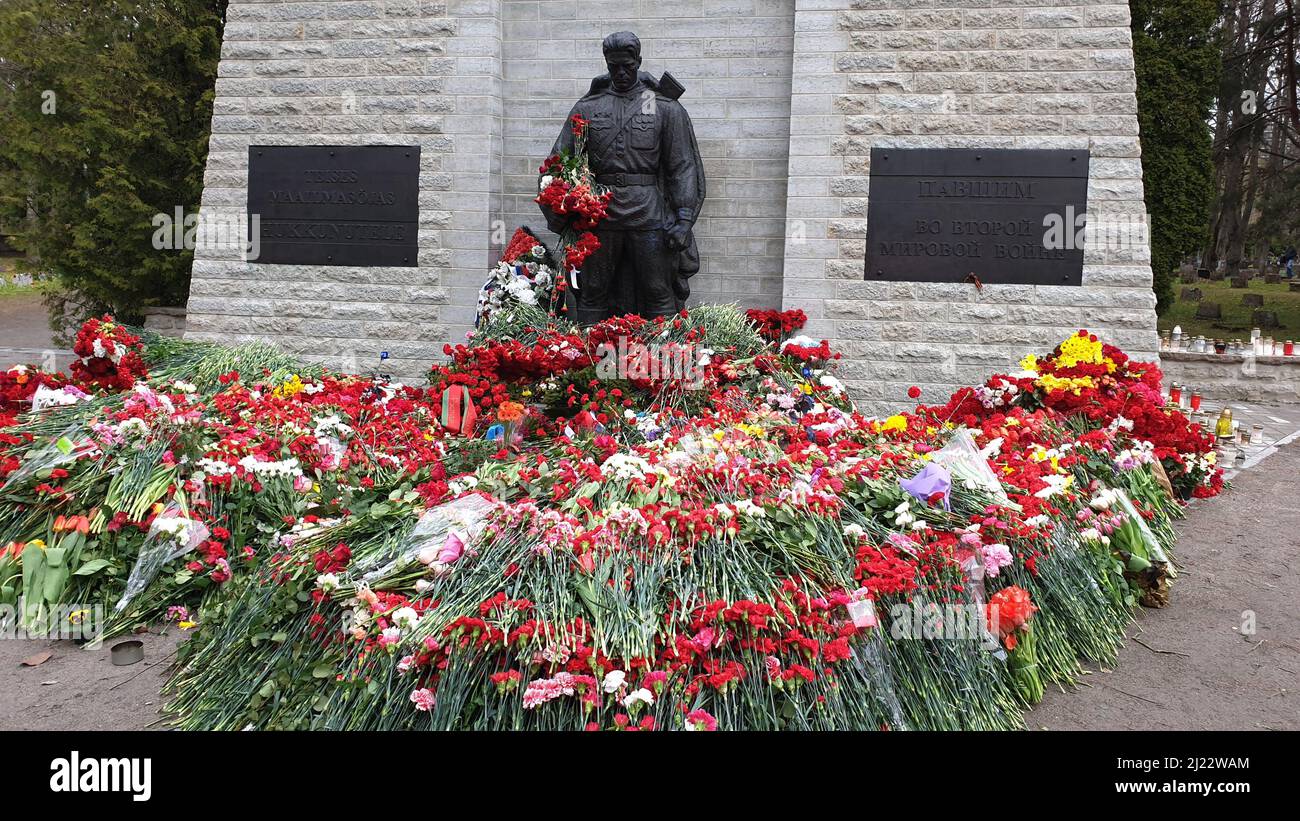 Tallinn, Estonia - May 9, 2021: Bronze Soldier (est: Pronkssõdur) monument. Red Army veterans celebrate Victory Day bringing red carnation flowers Stock Photo