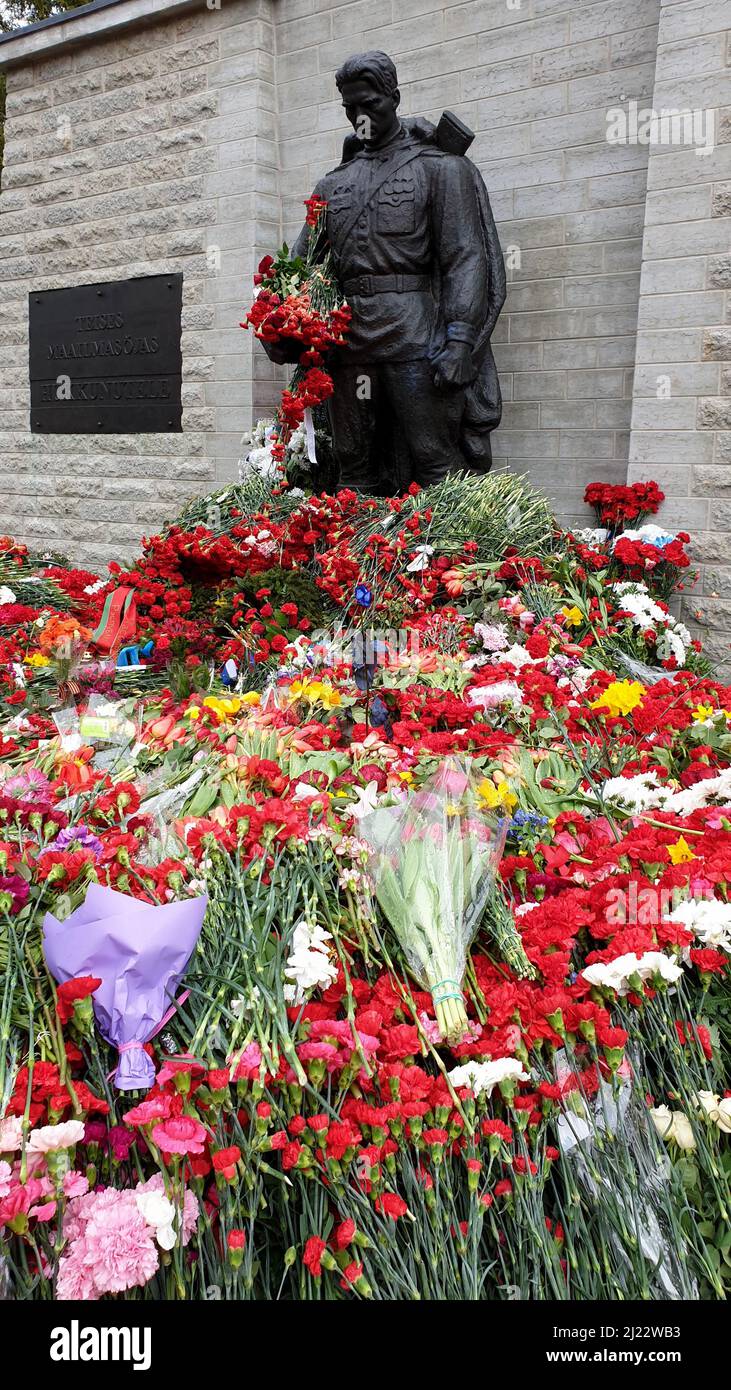 Tallinn, Estonia - May 9, 2021: Bronze Soldier (est: Pronkssõdur) monument. Red Army veterans celebrate Victory Day bringing red carnation flowers Stock Photo