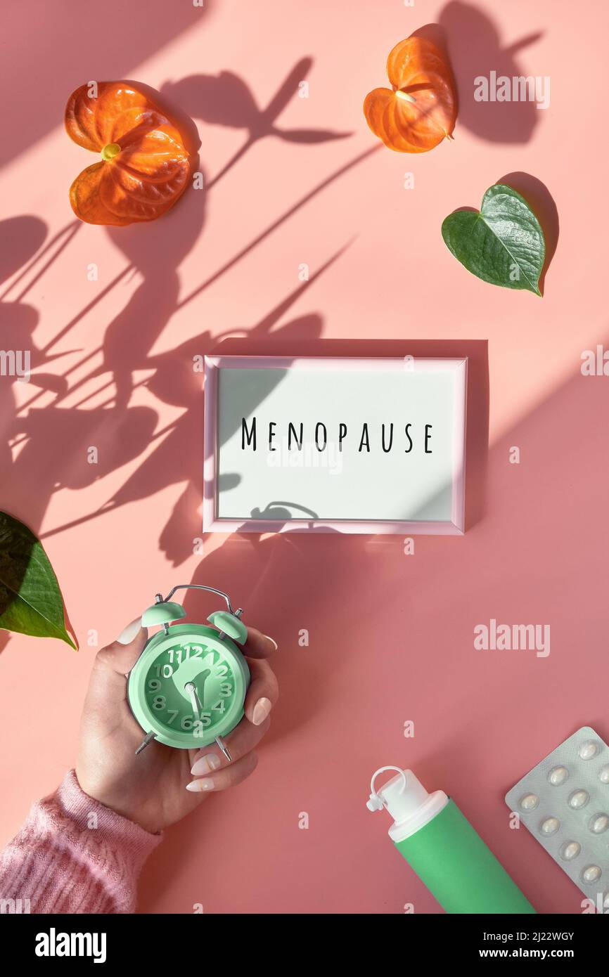 Text Menopause on light box in hand. HRT Replacement hormone therapy