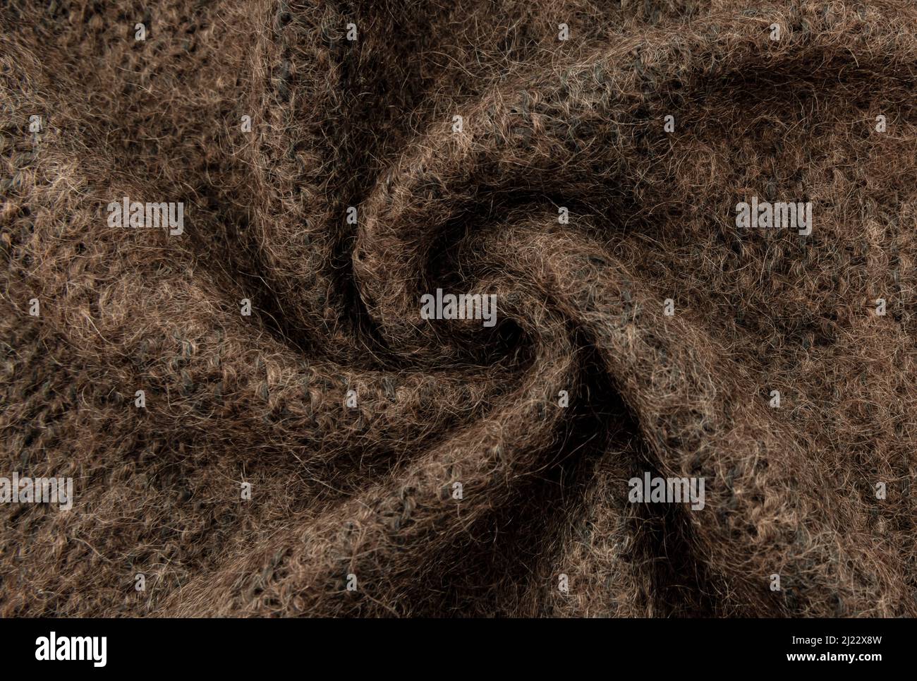 Twisted brown lambswool fabric with waves and curves. Wool material