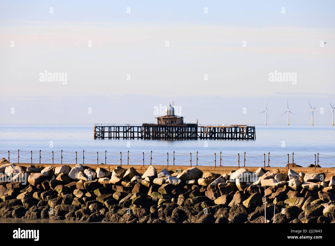 the derelict end of the old pier, with the Kentish Flats offshore wind farm turbines. Herne Bay, Kent, England Stock Photo