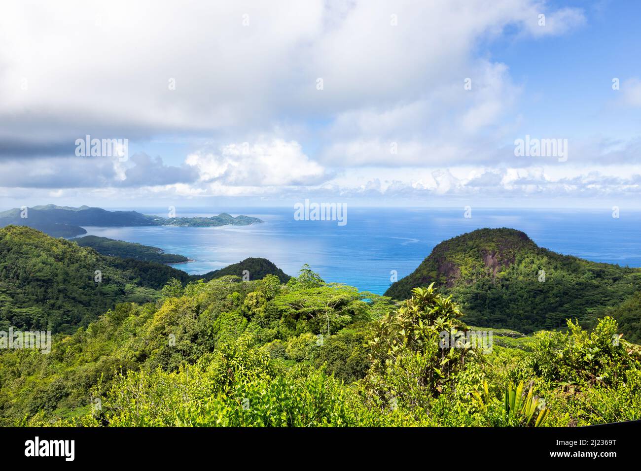 Landscape of Mahe Island coast seen from Venn's Town - Mission Lodge wooden viewing platform, lush tropical forest with crystal blue Indian Ocean. Stock Photo