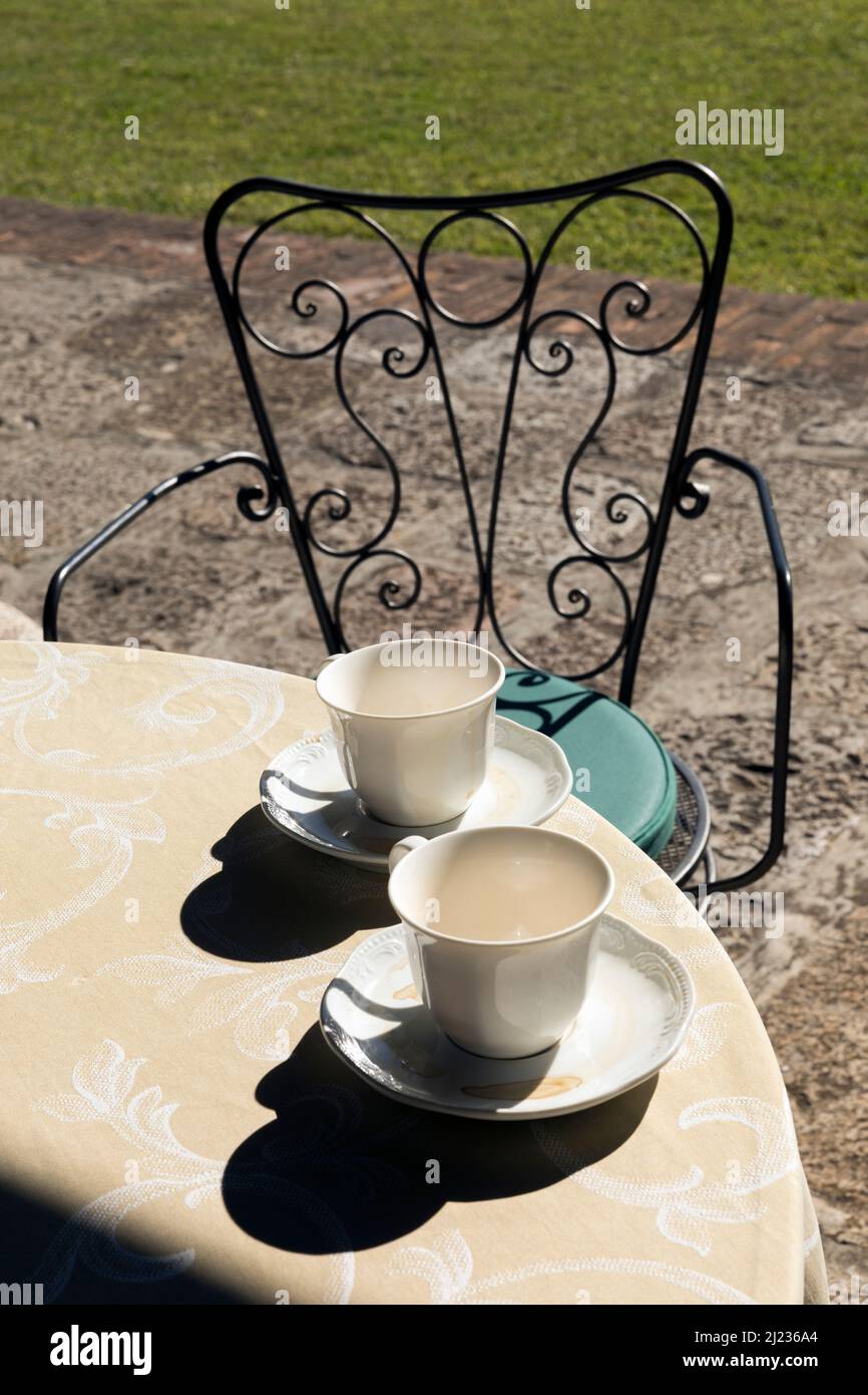 two empty coffee cups on a table set outdoors Stock Photo