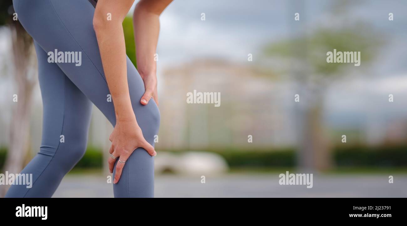 pain and from knee injury during morning run. Young woman