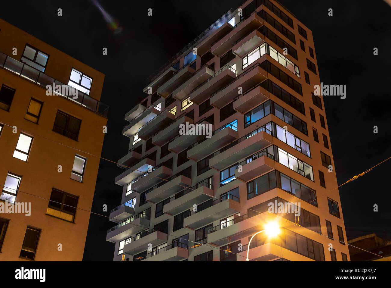 Bottom view of modern high residential house at night. Luxury apartments exteriors at night. Apartment loan. Stock Photo