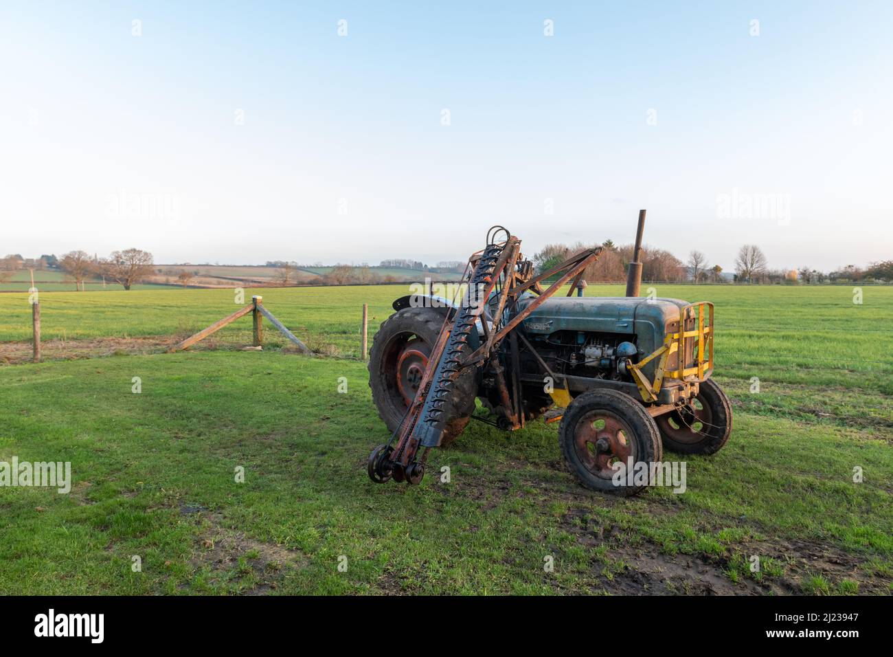 An old antique hedge trimmer mounted on a vintage tractor Stock Photo