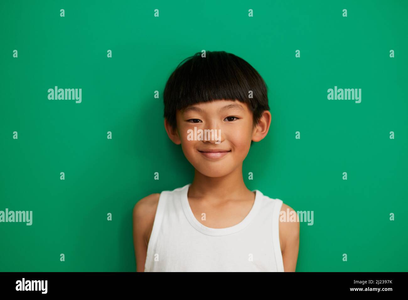 Its Great Being A Kid. Studio Portrait Of A Cheerful Little Boy Standing  Against A Green Background During The Day Stock Photo - Alamy