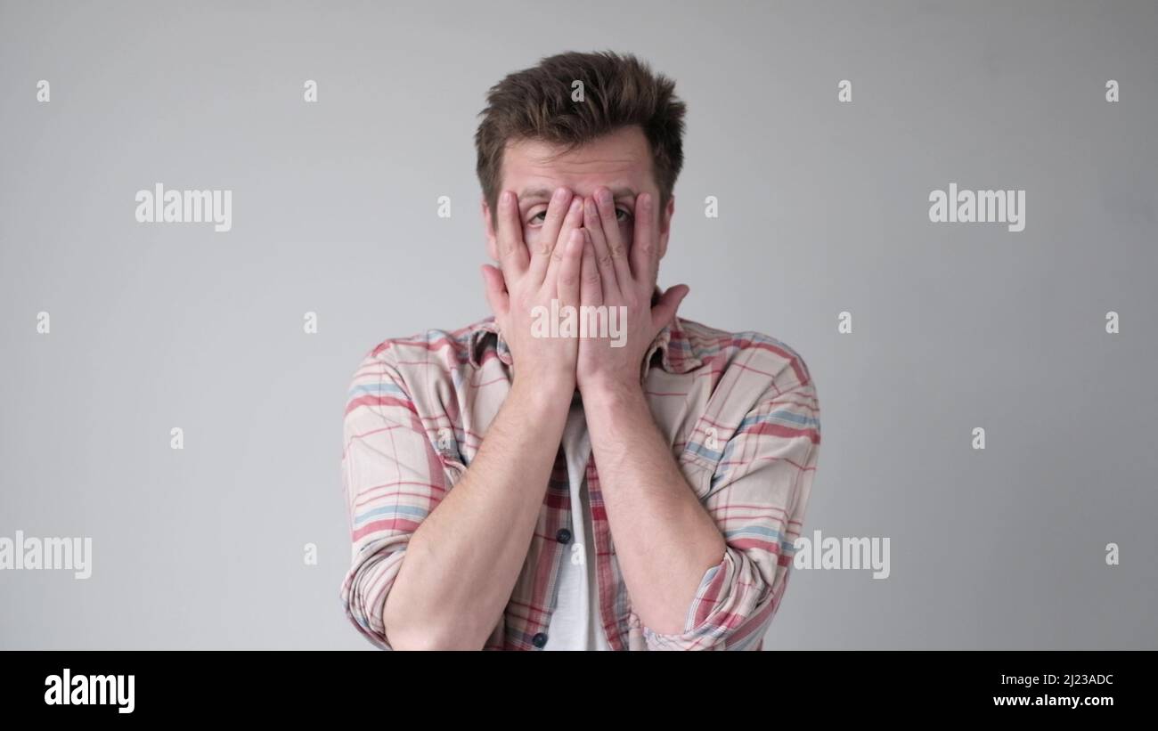 Desperate upset senior man holding hands on face. Studio shot Stock Photo