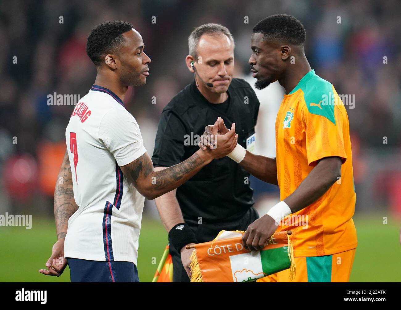 England captain Raheem Sterling (left) shake hands with Ivory Coast captain Serge Aurier before the international friendly match at Wembley Stadium, London. Picture date: Tuesday March 29, 2022. Stock Photo