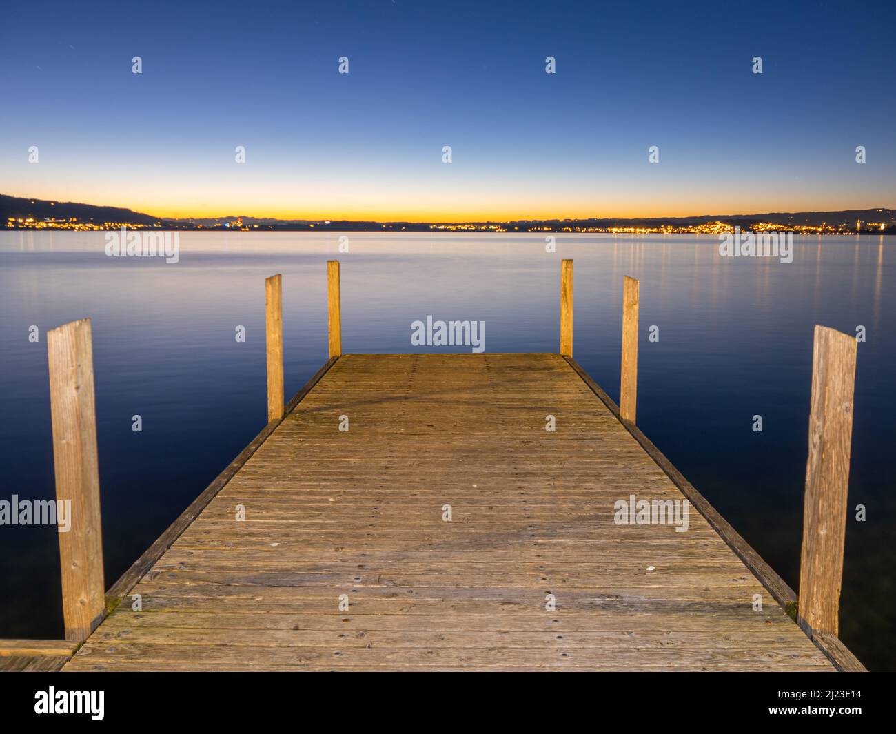 Zug, Switzerland - December 31, 2021: A wooden pier at Lake Zug in Switzerland on winter day after the sunset Stock Photo