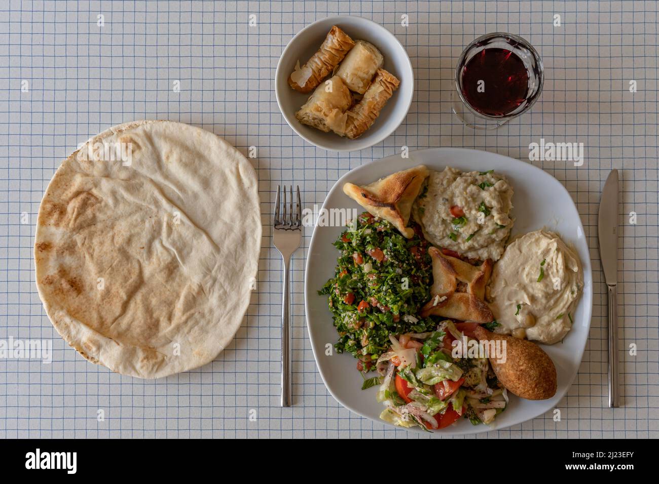 Top view of a plate of Lebanese specialties a pita bread and a bowl of
