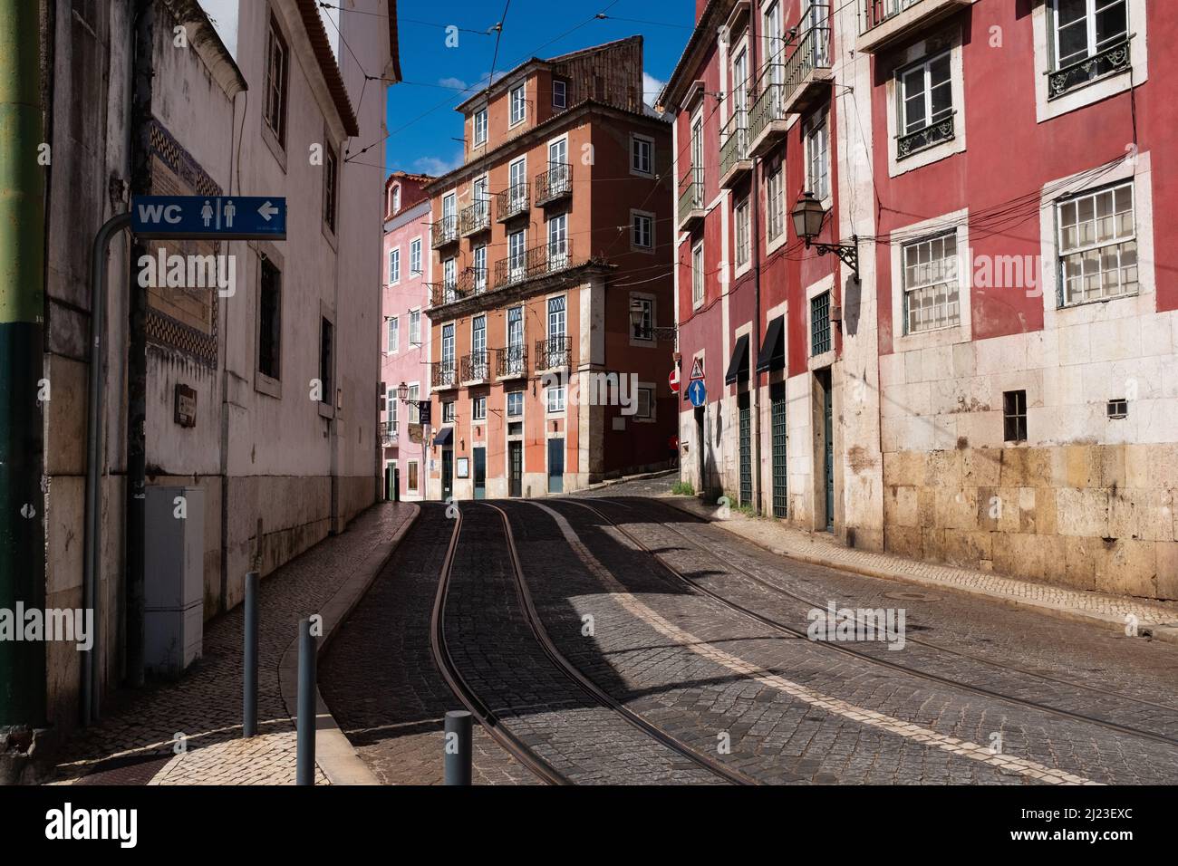 Narrow street in Lisbon Portugal with tram tracks public toilet on the side Stock Photo Alamy