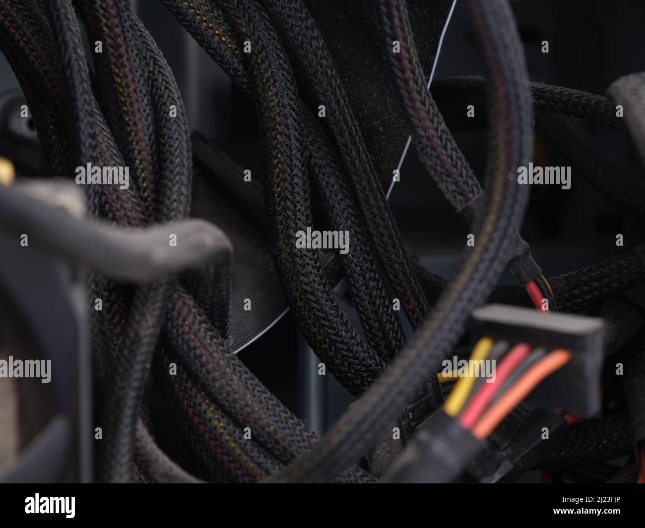 Some dusty power supply cables in a computer case with poor cable management. Close up. Stock Photo