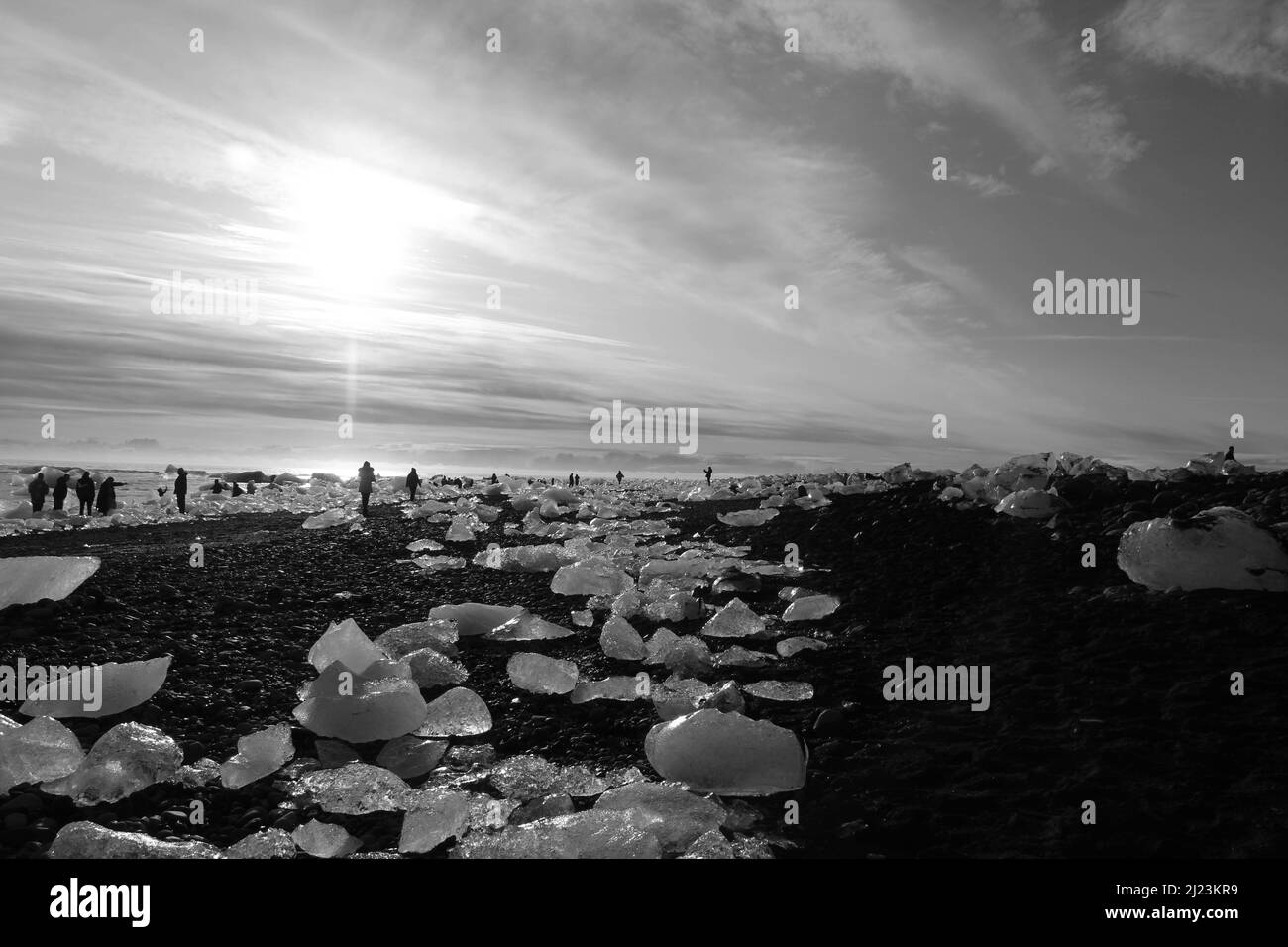 A grayscale view of glacial ice on the crystal beach with beautiful skyscape at Jokulsarlon, Vatnajokull National Park, Iceland Stock Photo