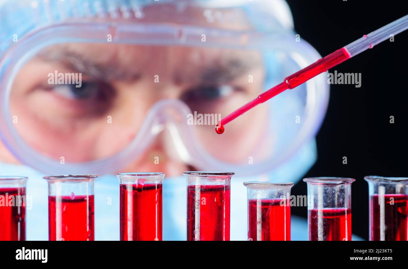 Blood test. Doctor or researcher with test tubes and pipette making