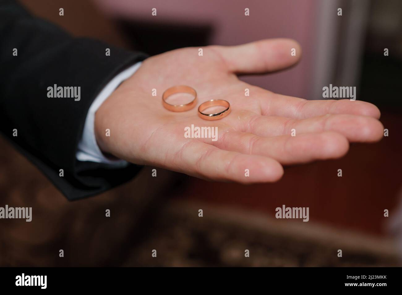 Wedding rings in the hands of the groom Stock Photo